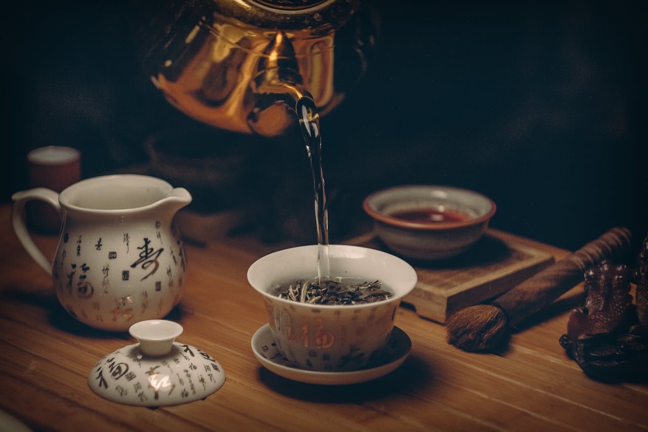 services-02 Artistic depiction of a traditional Chinese tea ceremony with porcelain teaware and hot water pour.